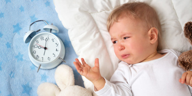 One year old baby with alarm clock